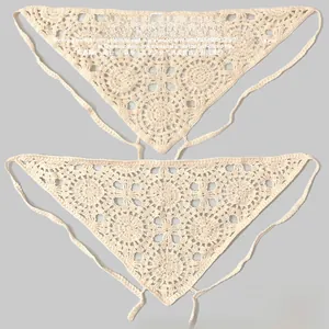 Détail macro du foulard triangle beige au crochet avec motifs floraux et lacets fins