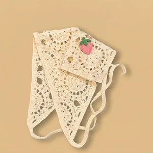 Détail de la texture tricotée du bandana beige au crochet avec fraises en relief
