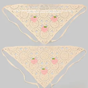 Détail d'un bandana triangulaire au crochet avec broderie de pêche et texture tricot