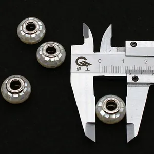 Makroaufnahme einer 14mm Muschelmosaikperle mit Messschieber für DIY Schmuckherstellung