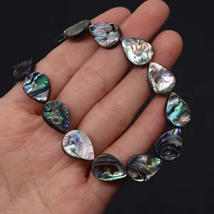 Gedetailleerde macro-opname van druppelvormige abalone schelpkralen met regenboogglans
