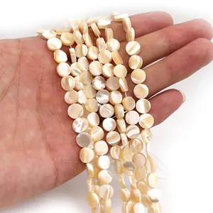 Close-up of flat round natural seashell beads with soft iridescent luster for DIY jewelry