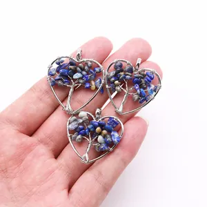 Close-up of handmade silver wire wrapped heart shaped life tree pendant with blue stones