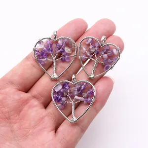 Detailed view of handmade heart-shaped tree of life pendants with purple natural stones