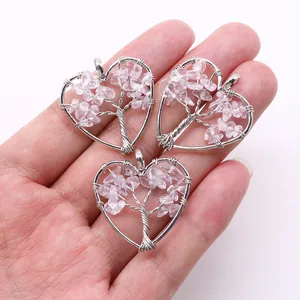 Macro view of three handmade wire wrapped heart tree of life pendants with pink stones