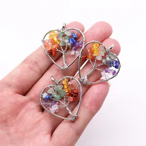 Macro detail of handmade wire-wrapped heart pendants featuring colorful Seven Chakra stones