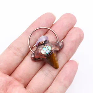 Detalle de un colgante boho vintage con amatista bruta concha de abalón y ojo de tigre