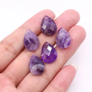 Macro shot of five faceted teardrop amethyst stones held in hand for jewelry making