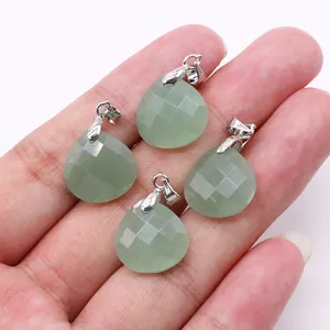 Macro view of four light green teardrop faceted stone pendants held in hand for detail