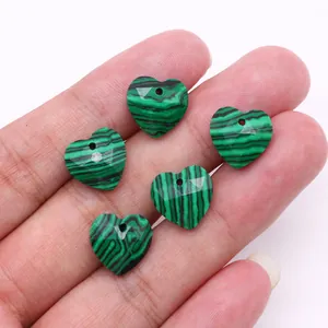 Detalle macro de cinco piedras de malaquita facetadas en forma de corazón para collares
