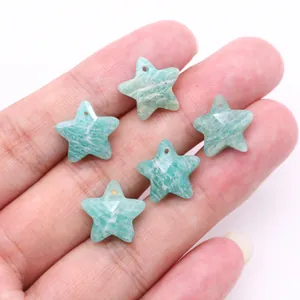 Close-up of faceted star-shaped amazonite natural stone pendants held in hand