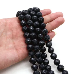 Detalle de cuentas de piedra negra pulida con patrones de grietas blancas para joyería