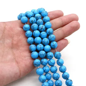 Primer plano de cuentas redondas de turquesa azul con vetas negras para bisutería artesanal