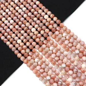 Polished natural sunstone round beads in soft orange-pink hue for DIY jewelry making