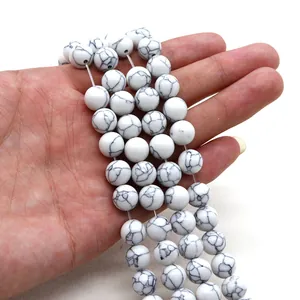 Primer plano de cuentas redondas de howlita blanca con vetas negras para joyería artesanal