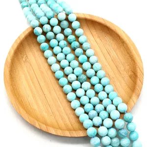 Polished natural Amazonite round beads arranged on a wooden tray for DIY jewelry making