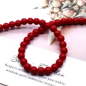 Cuentas redondas de vidrio rojo pulido para joyería DIY sobre fondo floral