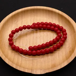 Cuentas redondas de piedra natural roja pulida en bandeja de madera para joyería DIY