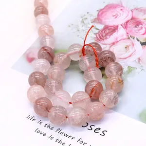 Polished natural pink stone round beads for DIY jewelry making on aesthetic floral background