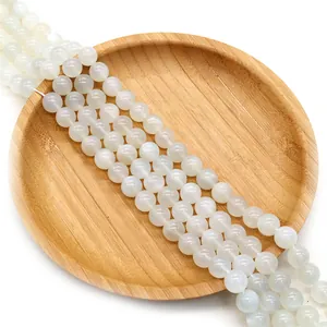 Natural white moonstone round beads for DIY jewelry making displayed on a bamboo tray