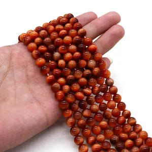 Dettaglio di perle in occhio di tigre rosso con effetto occhio di gatto e finitura lucida