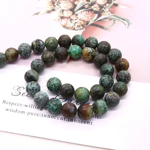 Natural African turquoise round beads for DIY jewelry making displayed in an S-curve