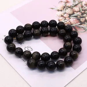 Bracelet double rang en obsidienne dorée avec reflets dorés et fond artistique élégant