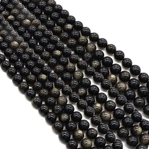 Brins de perles en obsidienne dorée naturelle avec reflets métalliques sur fond blanc
