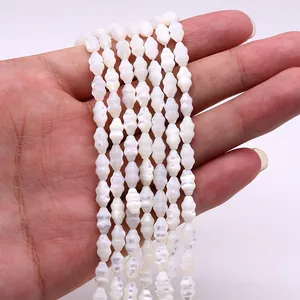 Macro detail of white mother-of-pearl spindle beads with natural iridescent luster