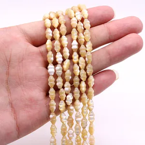 Close-up of iridescent cream shell beads in a unique lantern shape for jewelry making