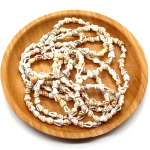 Natural freshwater shell necklace on a wooden tray with neutral white background