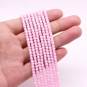 Vista macro de pequeñas cuentas cúbicas rosas para creación de joyería DIY y collares