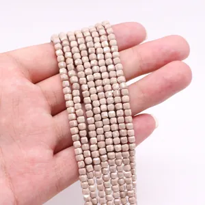 Vista detallada de cuentas de piedra natural facetadas beige para joyería artesanal