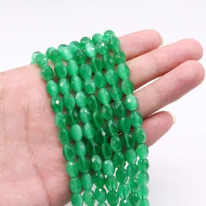 Macro-opname van groene gefacetteerde kattenoogkralen in ovale vorm voor DIY-sieraden maken