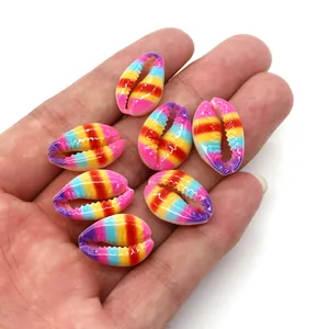 Polished rainbow gradient cowrie shell beads for DIY jewelry making held in hand