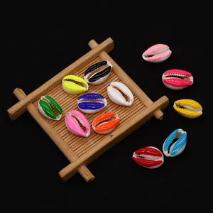 Colorful resin cowrie shell beads for DIY necklaces displayed on a bamboo tray