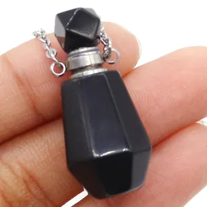 Natural black gemstone perfume bottle pendant with silver chain held in hand