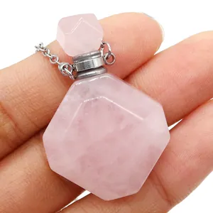 Detailansicht eines geometrischen rosa Kristall Parfümflaschen-Anhängers in der Hand