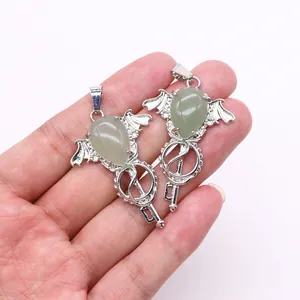 Detailed close-up of fantasy angel wing scepters with green teardrop crystal stones