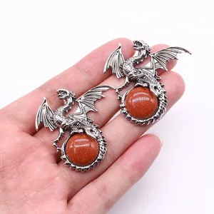 Detail of silver-plated dragon pendant featuring a polished red sandstone bead inlay