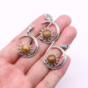 Detailed view of three silver sun and crescent moon pendants with brown natural stones