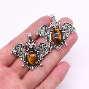 Macro detail of bat-shaped Tiger Eye stone pendants with antique silver alloy wings