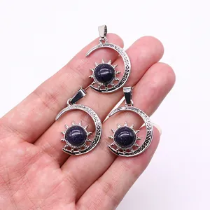 Three celestial sun and moon pendants with blue sand stone inlay held by a hand