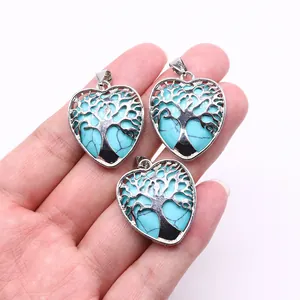 Detailed view of three heart-shaped pendants with Tree of Life engraving and green stone