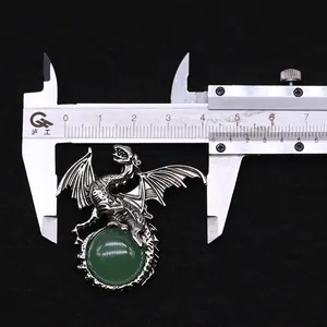Detail shot measuring 4cm width of retro silver dragon pendant with green gemstone