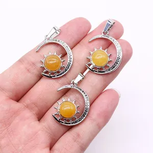 Detailed view of three silver crescent moon and sun pendants with amber gemstones
