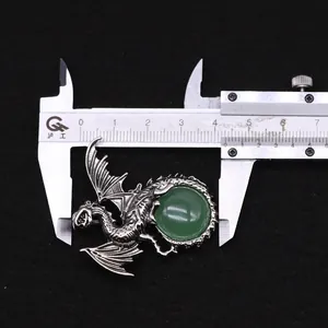 Detailed macro view of silver viking dragon pendant with green stone and caliper measurement