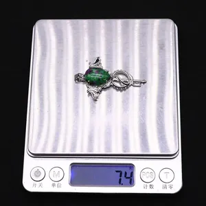 Detailed view of Ruby Zoisite wing wand pendant showing 7.4g weight on digital scale
