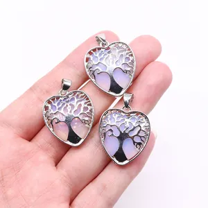 Detailed view of three heart-shaped Tree of Life pendants with rainbow opal gemstones