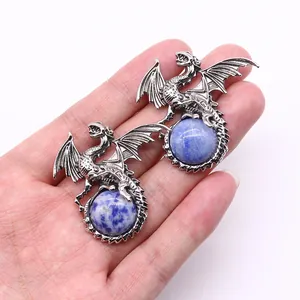 Vintage silver dragon pendant holding a blue round natural stone held in hand